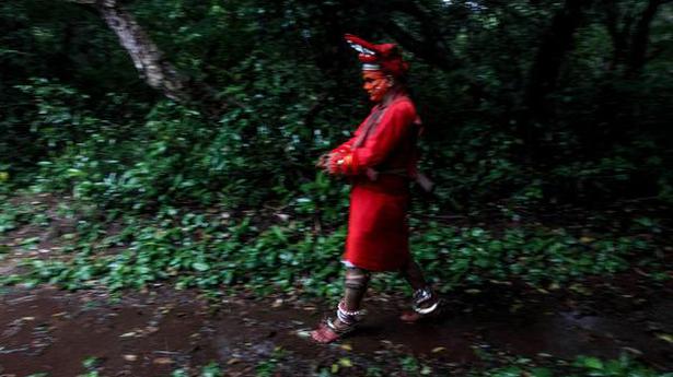Fitting all elements: Haridasan comes out from the aniyara (green room) to the sacred grove to wear the headgear.