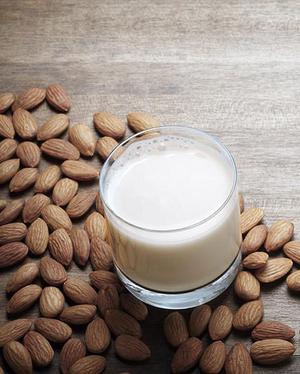 almond milk surrounded by almonds -  substitute for milk in diet.