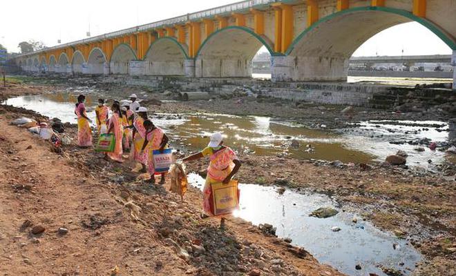 Conservancy workers cleaning waste from the banks of the Vaigai near AV bridge in Madurai on Saturday.