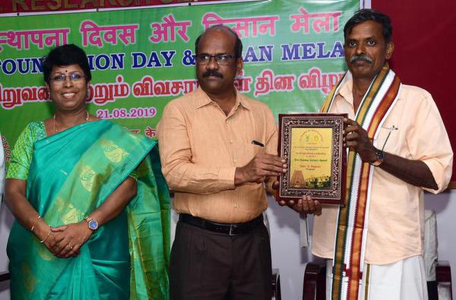 Collector S. Sivarasu presenting the best farmer award to S. Rajesh of Thottiam near Tiruchi on Wednesday.