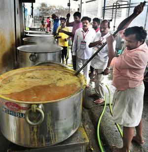 Cooks preparing sambar and other items at temple kitchen in Vijayawada.