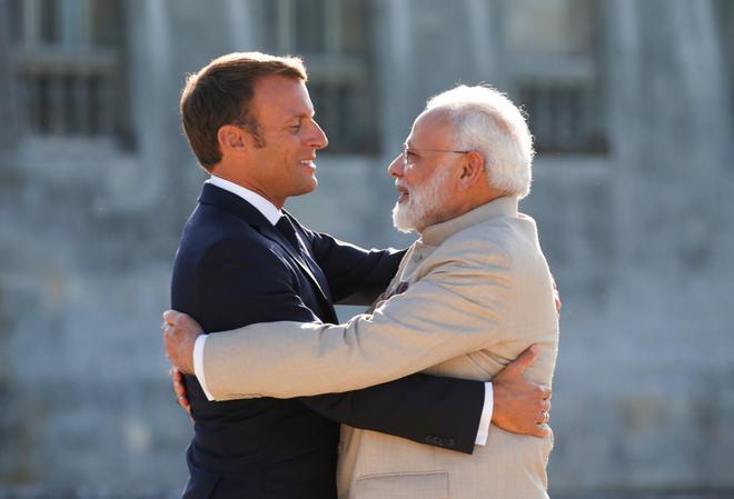 French President Emmanuel Macron hugs Prime Minister Narendra Modi as he welcomes him before their meeting at the Chateau of Chantilly, near Paris on August 22, 2019.