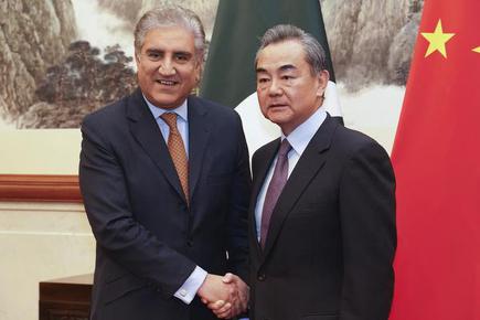 Pakistan Foreign Minister Shah Mahmood Qureshi (left) and Chinese Foreign Minister Wang Yi shake in Beijing. File photo