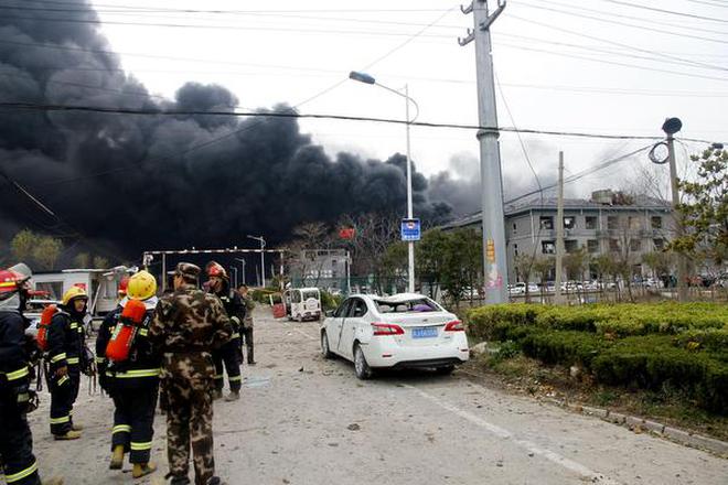 In this Thursday, March 21, 2019, photo, rescuers walk near the site of a factory explosion in a chemical industrial park in Xiangshui County of Yancheng in eastern China's Jiangsu province.
