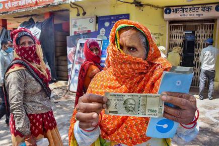 An elderly woman shows a 500 rupee note after withdrawing from her Jan Dhan account, after the Centre released its second installment of the COVID-19 lockdown relief fund, in Mathura, Uttar Pradesh. File photo