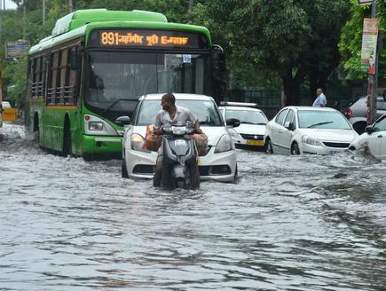 Vehicles wade through water-logged roads at Jahangirpuri in North Delhi following heavy rains on July 19, 2020.