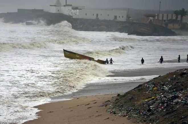 Fishermen try to pull back a boat that was carried away by waves on the Arabian Sea coast in Veraval, Gujarat, India, Thursday, June 13, 2019.